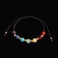 Pulsera de los 7 chakras con piedras naturales y cuentas doradas sobre fondo negro